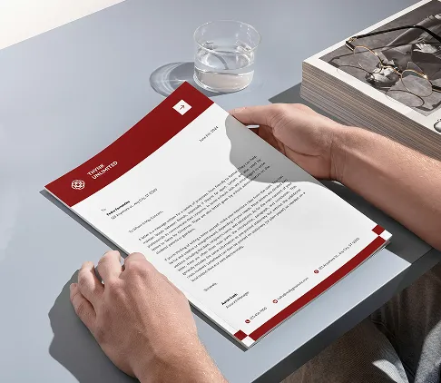 Person hält Briefkopf eines Unternehmens, professionell gestaltet